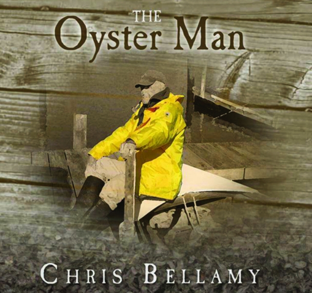 old fisherman wearing yellow rain jacket sitting on pier